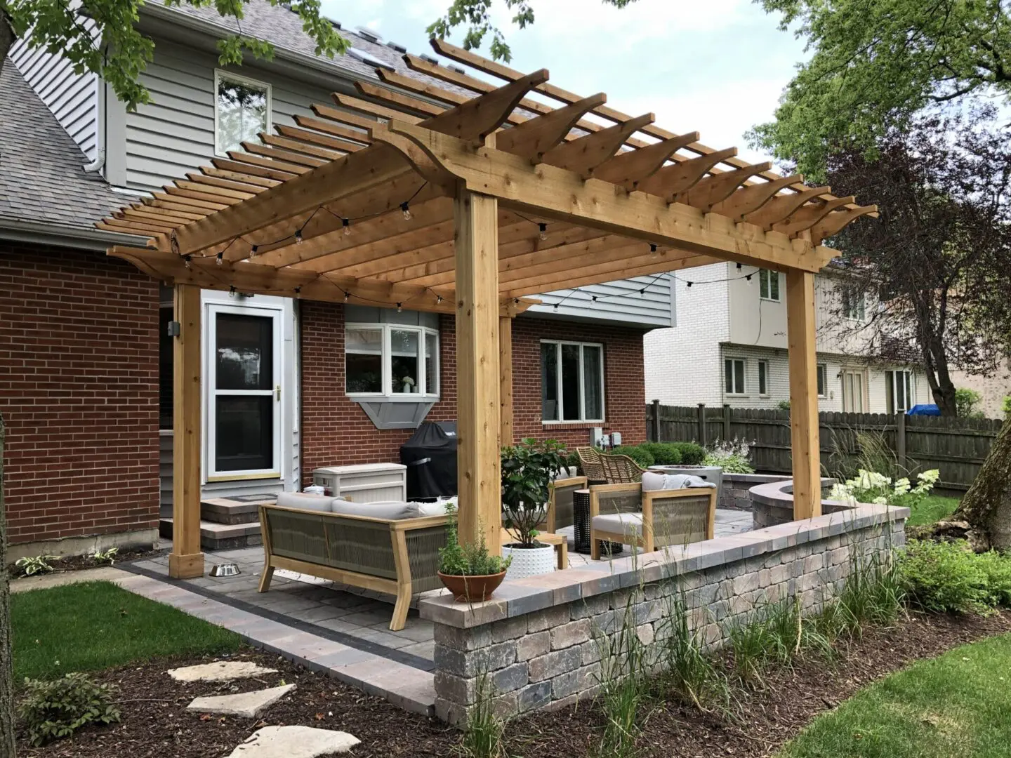 Custom patio with pergola, seating walls, and firepit in Downers Grove, IL