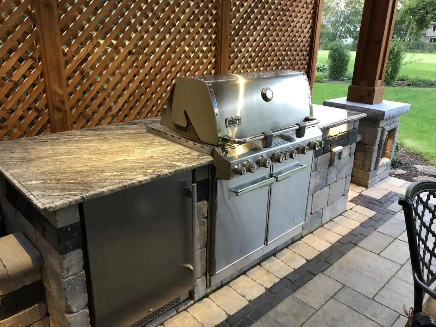 Stone outdoor kitchen cabinet with granite countertop installation in Hinsdale, IL