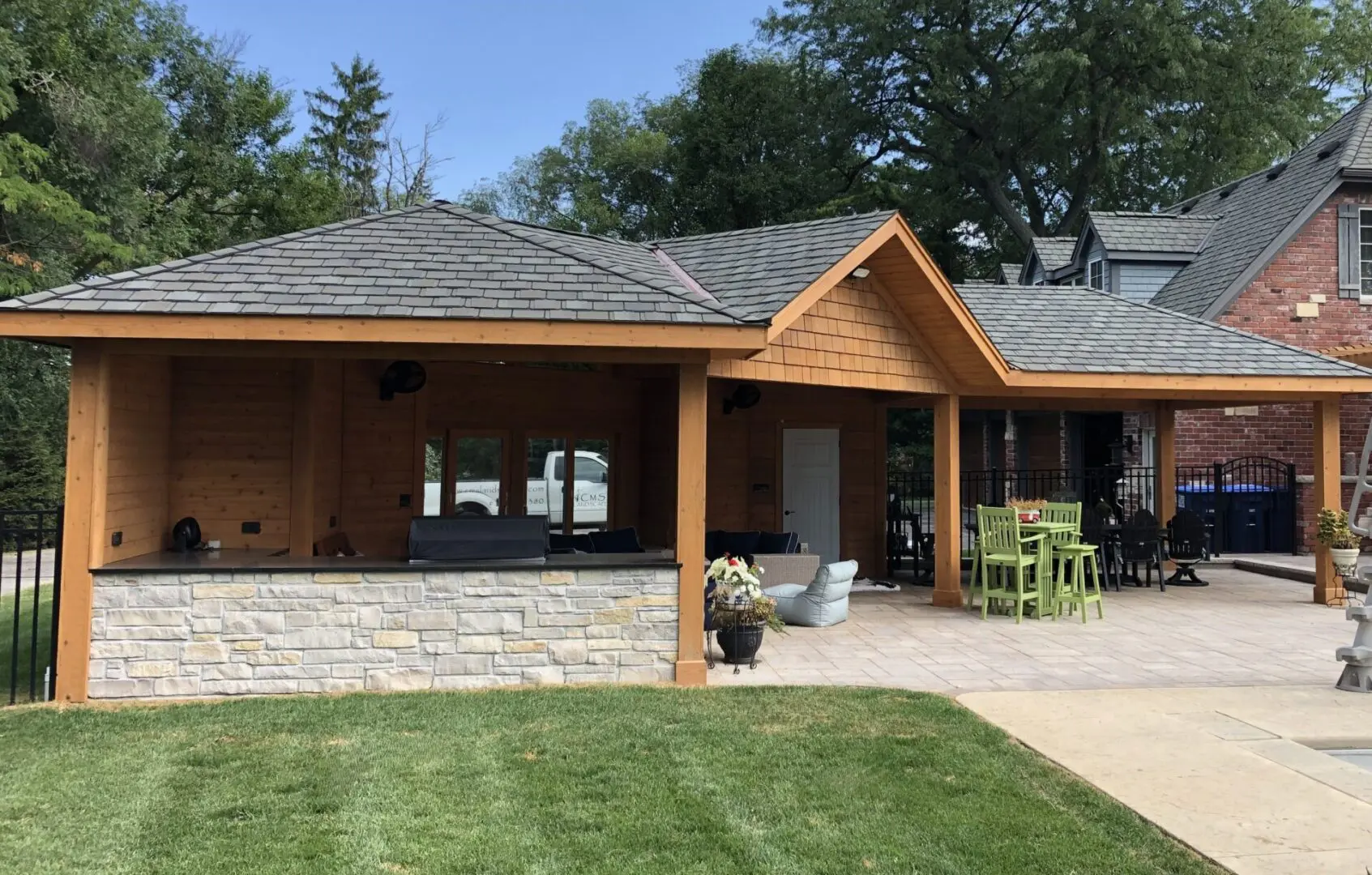 Outdoor roof structure with outdoor kitchen, custom fire pit, and seating area in Lisle, IL