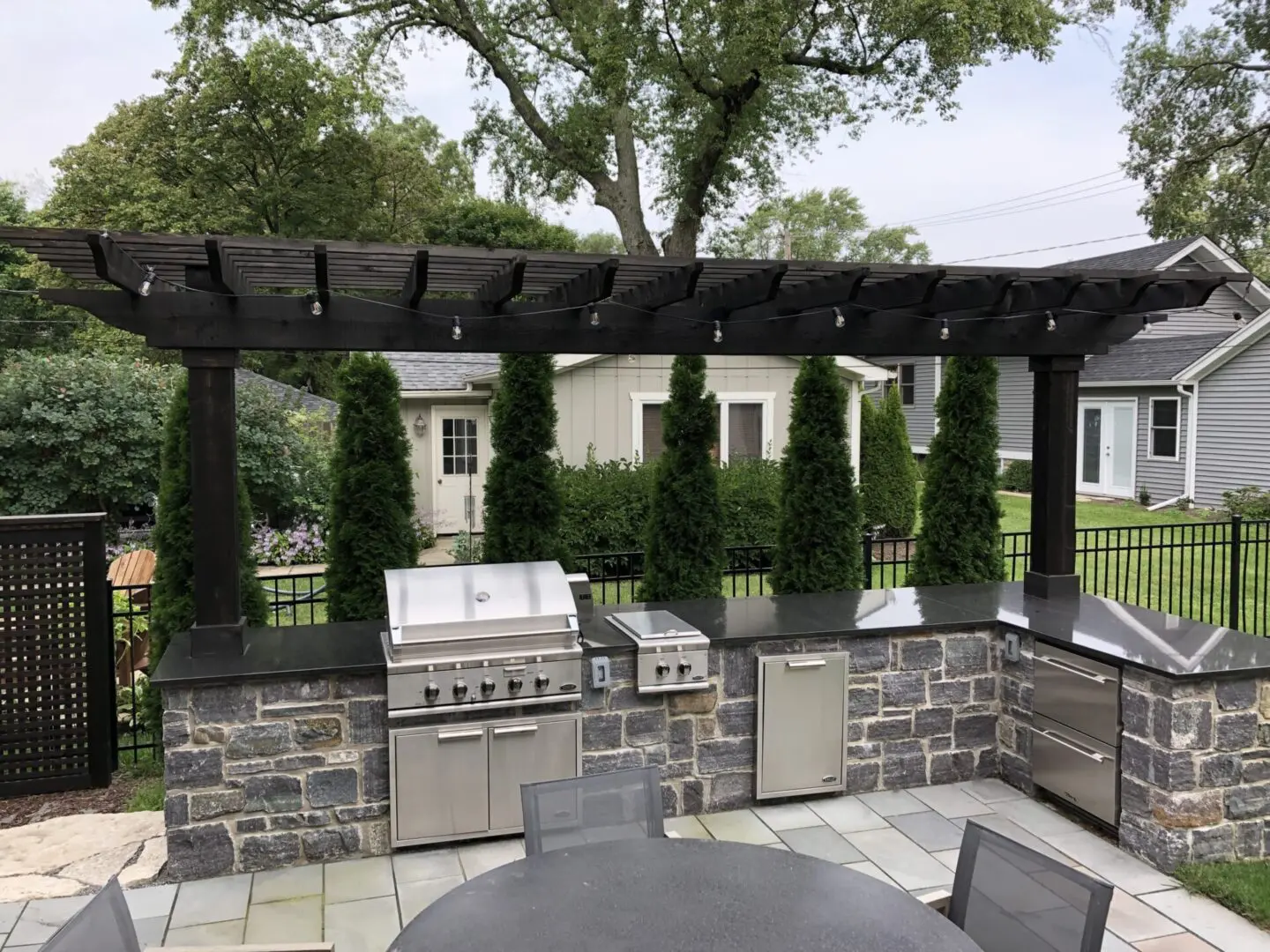 Wood pergola and outdoor kitchen with built in grill and refrigerator in Clarendon Hills, IL