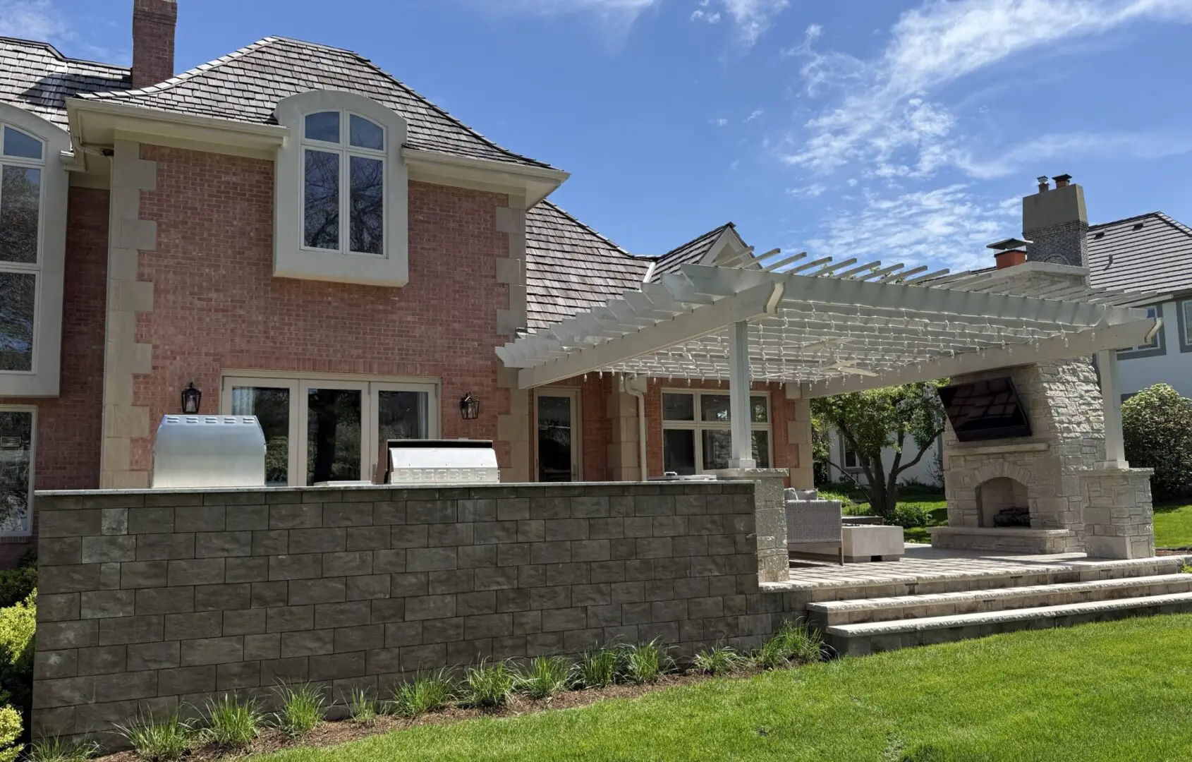 Custom patio with fire place, outdoor kitchen, and pergola in Oak Brook, IL