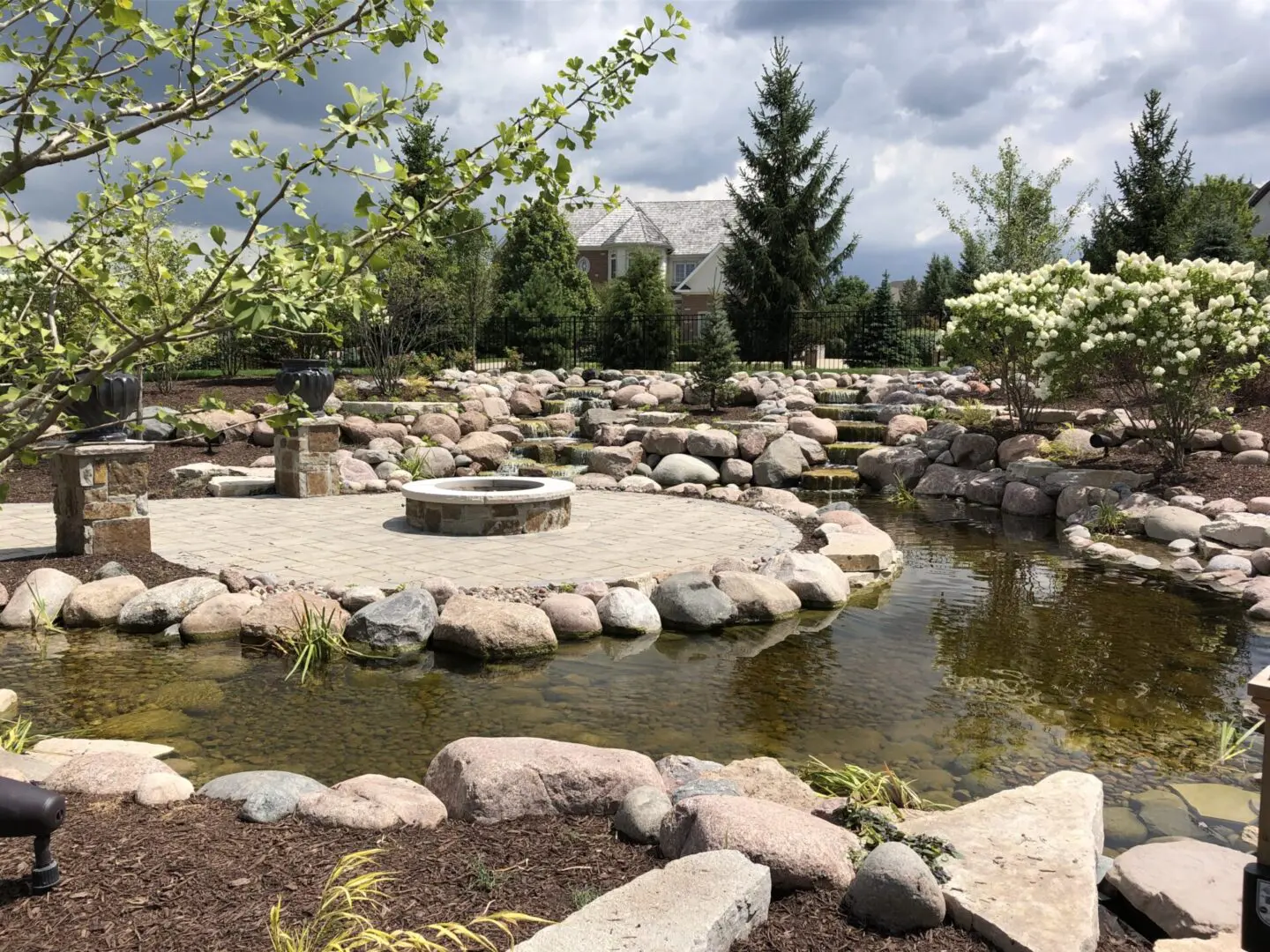 Custom paver patio with fire pit and pond in Palos Park, IL