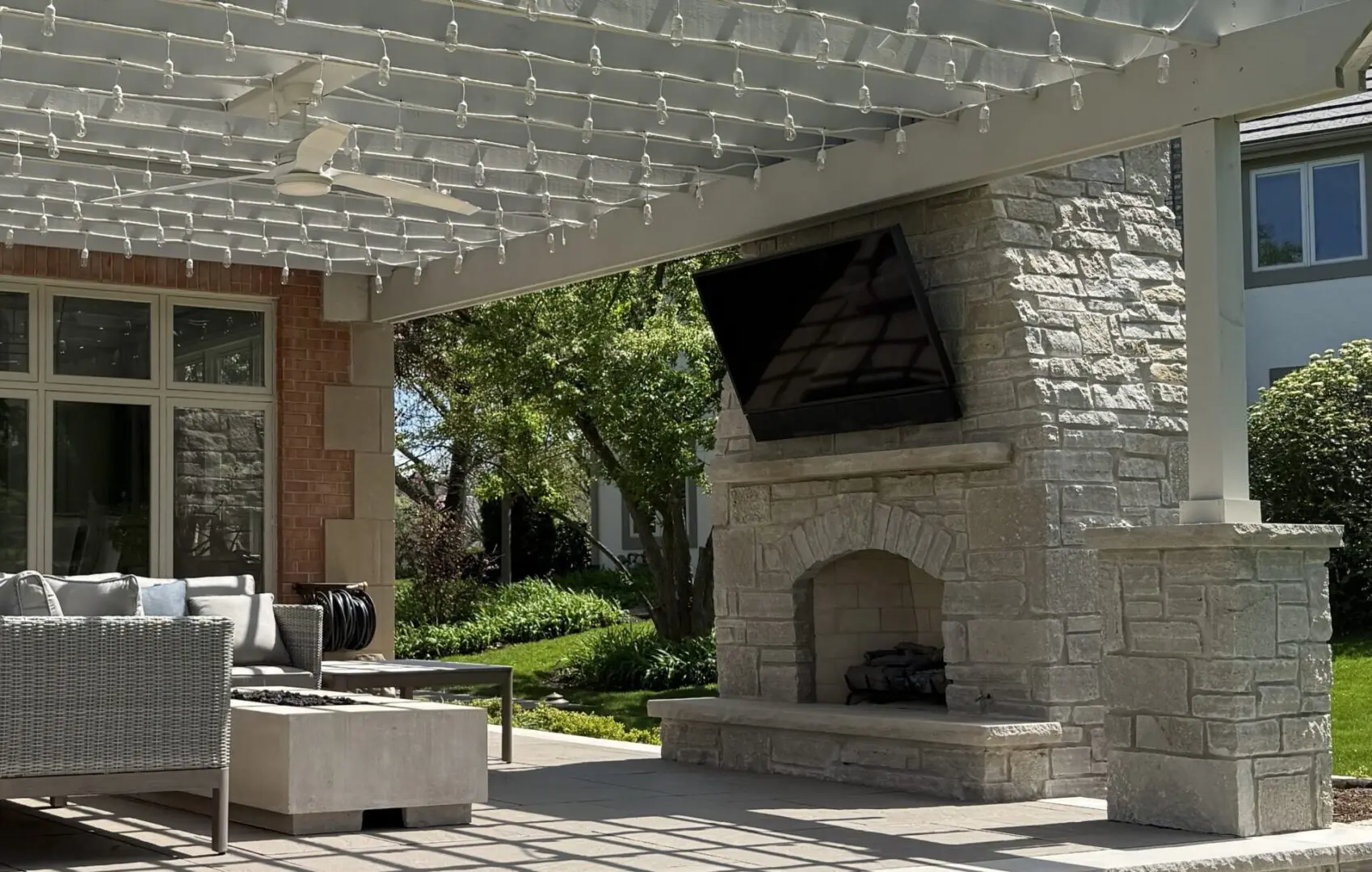 Natural stone patio with custom fireplace and pergola in Oak Brook IL