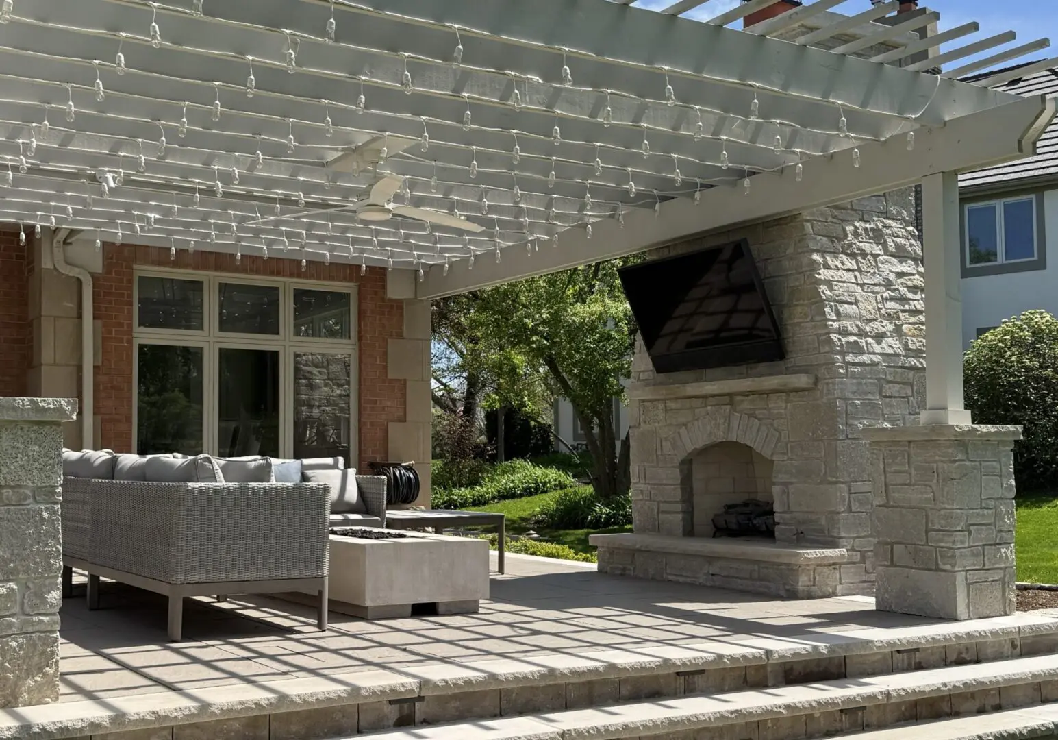 Natural stone patio with custom fireplace and pergola in Oak Brook IL