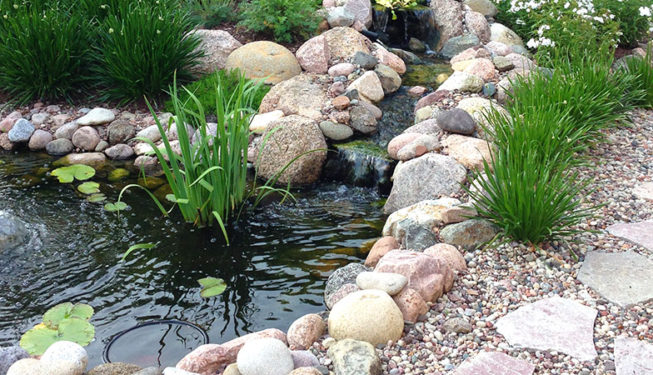 Small artificial rocky pond with fountain