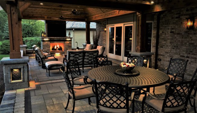 A Spacious Patio with Tables Chairs and a Fireplace