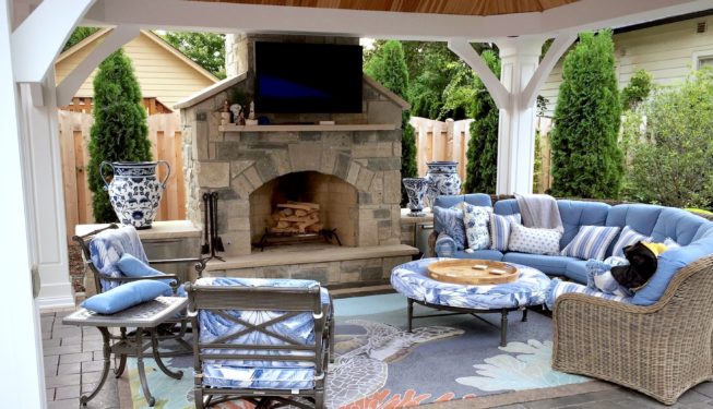 Outdoor fireplace with couches and TV